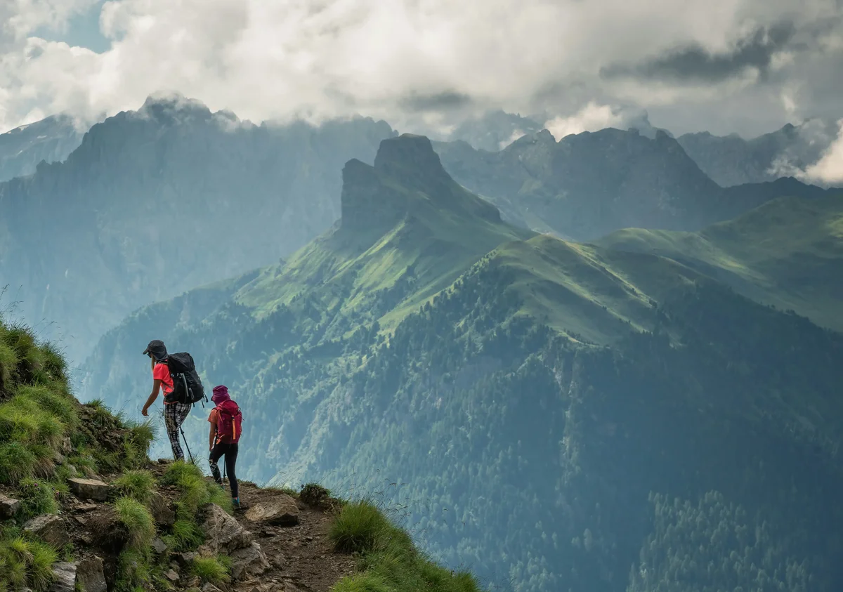 Expedition leader guiding a group through a dramatic mountain landscape, representing immersive experiential travel leadership recruitment