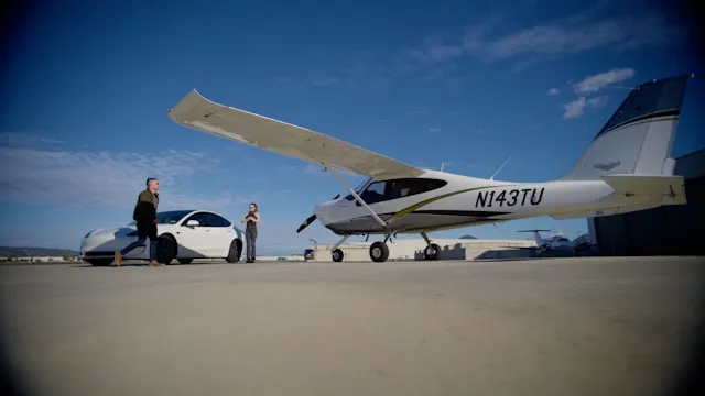A private plane parked beside a luxury vehicle at a private airport on a sunny summer day, representing luxury travel executive careers